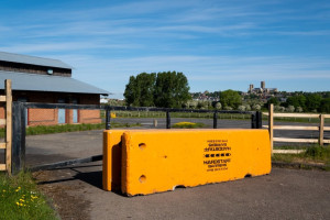 Yellow Multibloc with Hardstaff Barriers logo installed at vacant site